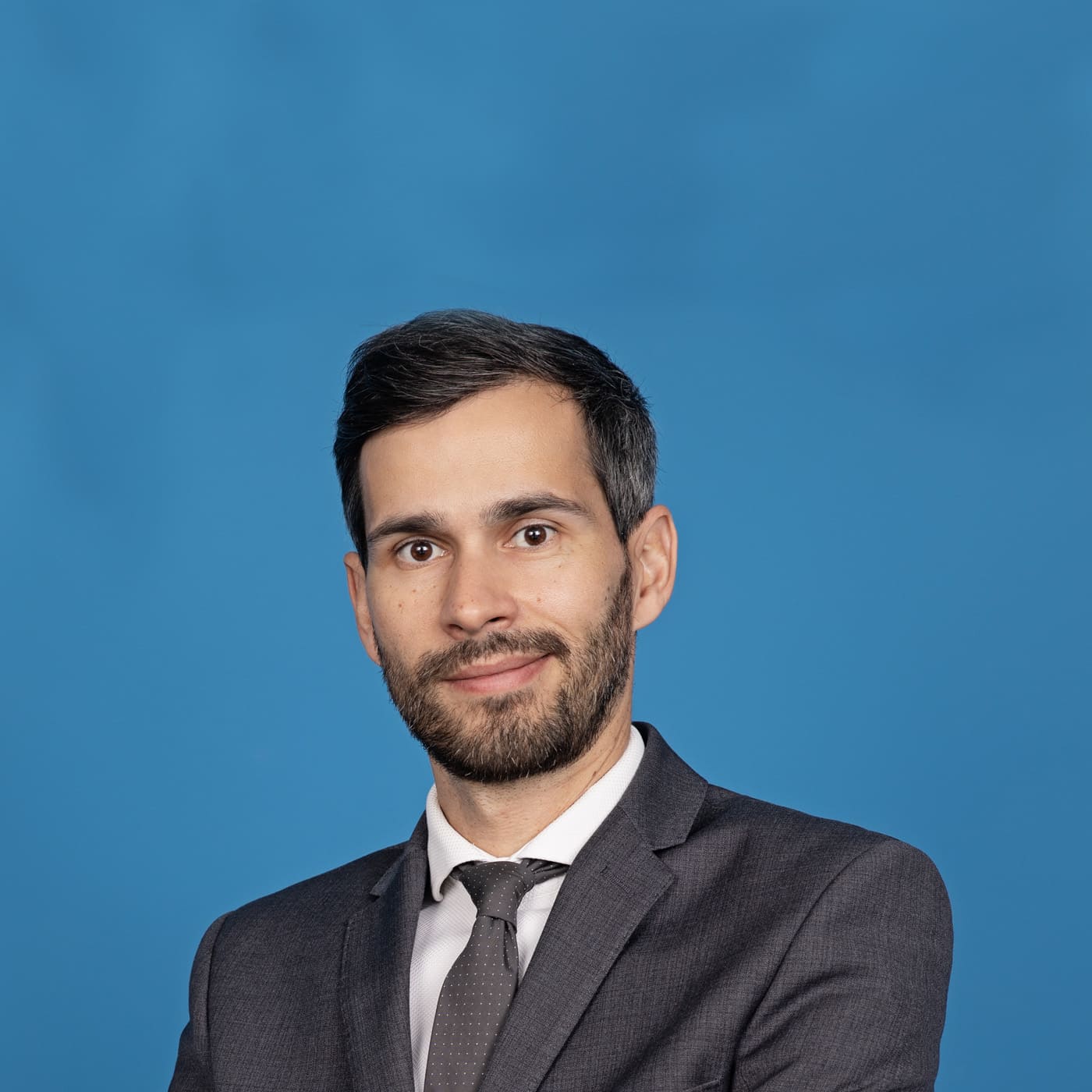 Man smiling in front of blue background