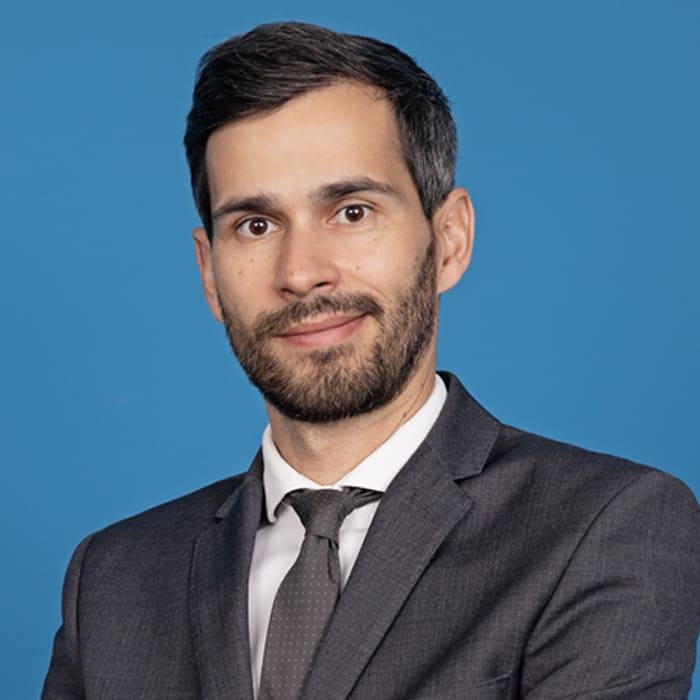 Man smiling in front of blue background