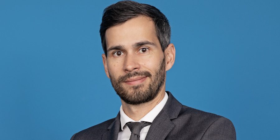 Man smiling in front of blue background